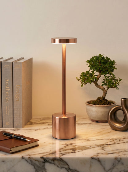 Rose Gold Egret Lamp on a white marble shelf with a bonsai tree and stacked books