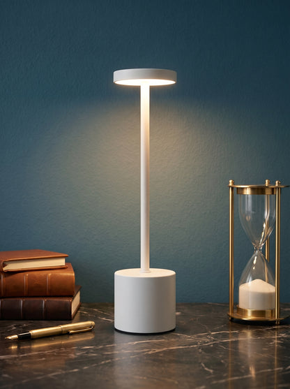 White Egret Lamp on a dark marble desk against a teal wall with leather books and a brass hourglass