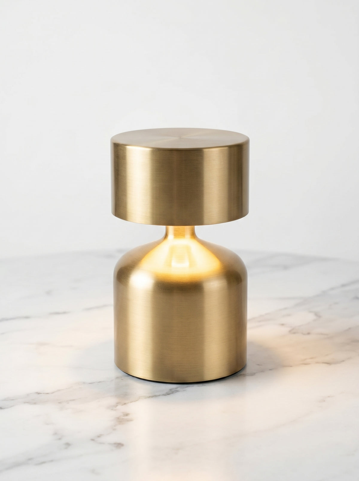 Gold Pipit Lamp on a white marble surface against a plain white background