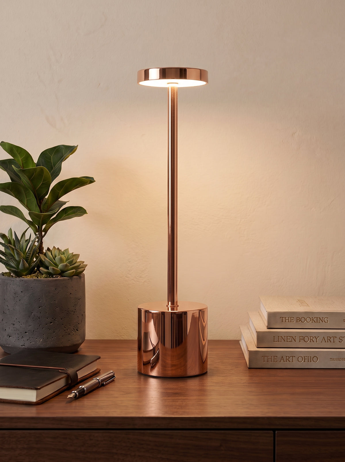 Rose Gold Egret Lamp on a wooden desk next to a potted succulent and a stack of books