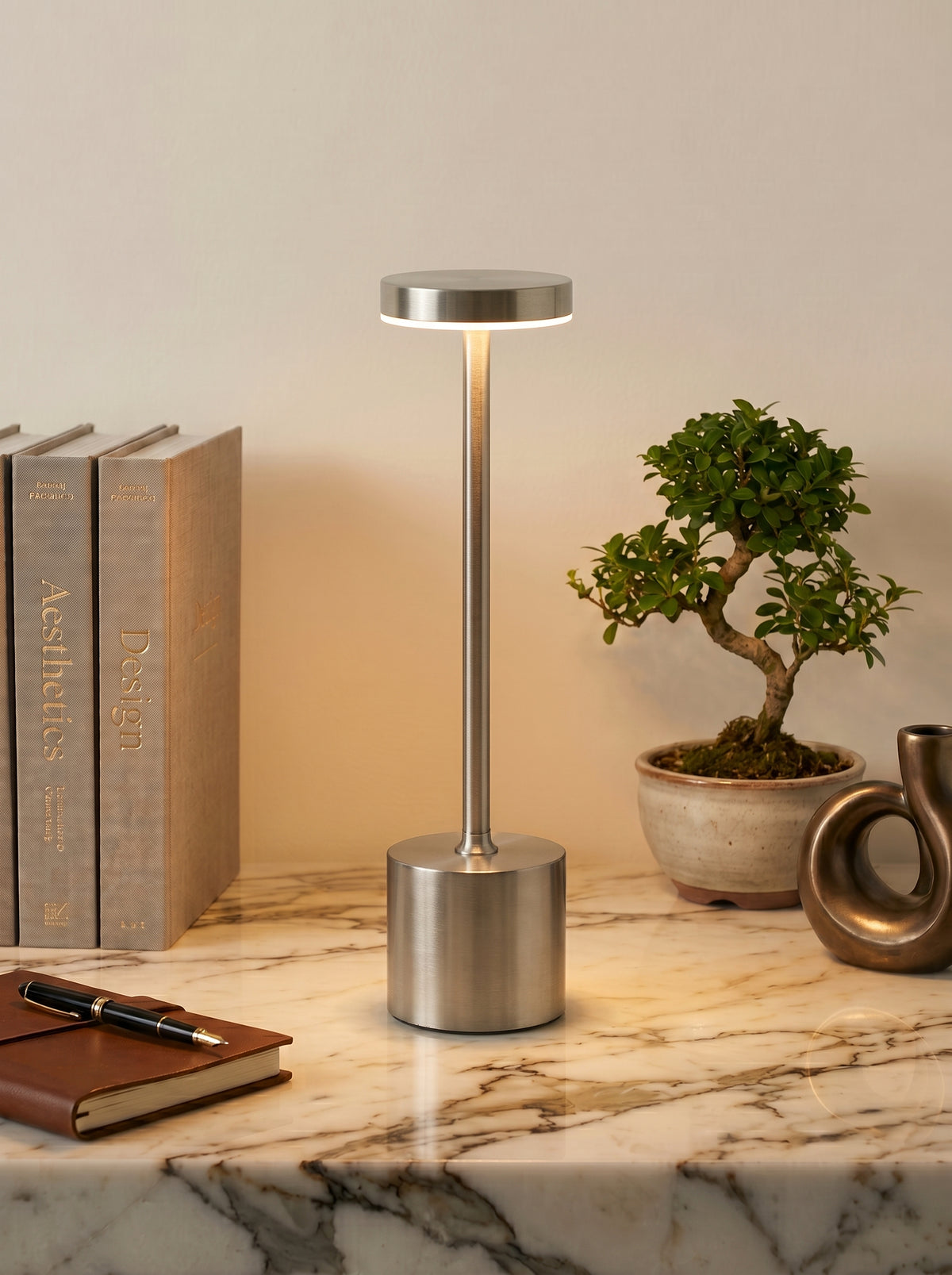 Silver Egret Lamp on a white marble shelf beside a bonsai tree and linen-bound books