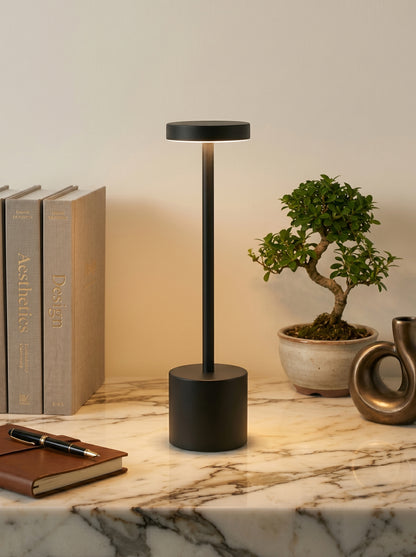 Black Egret Lamp on a white marble shelf with a bonsai tree and linen-bound books