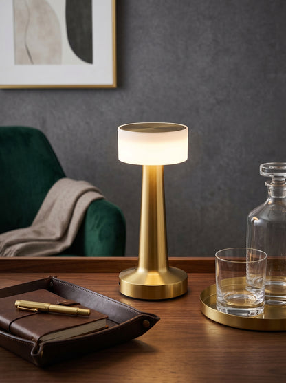 Gold Aix Lamp on a desk beside a crystal decanter, a glass and a leather tray