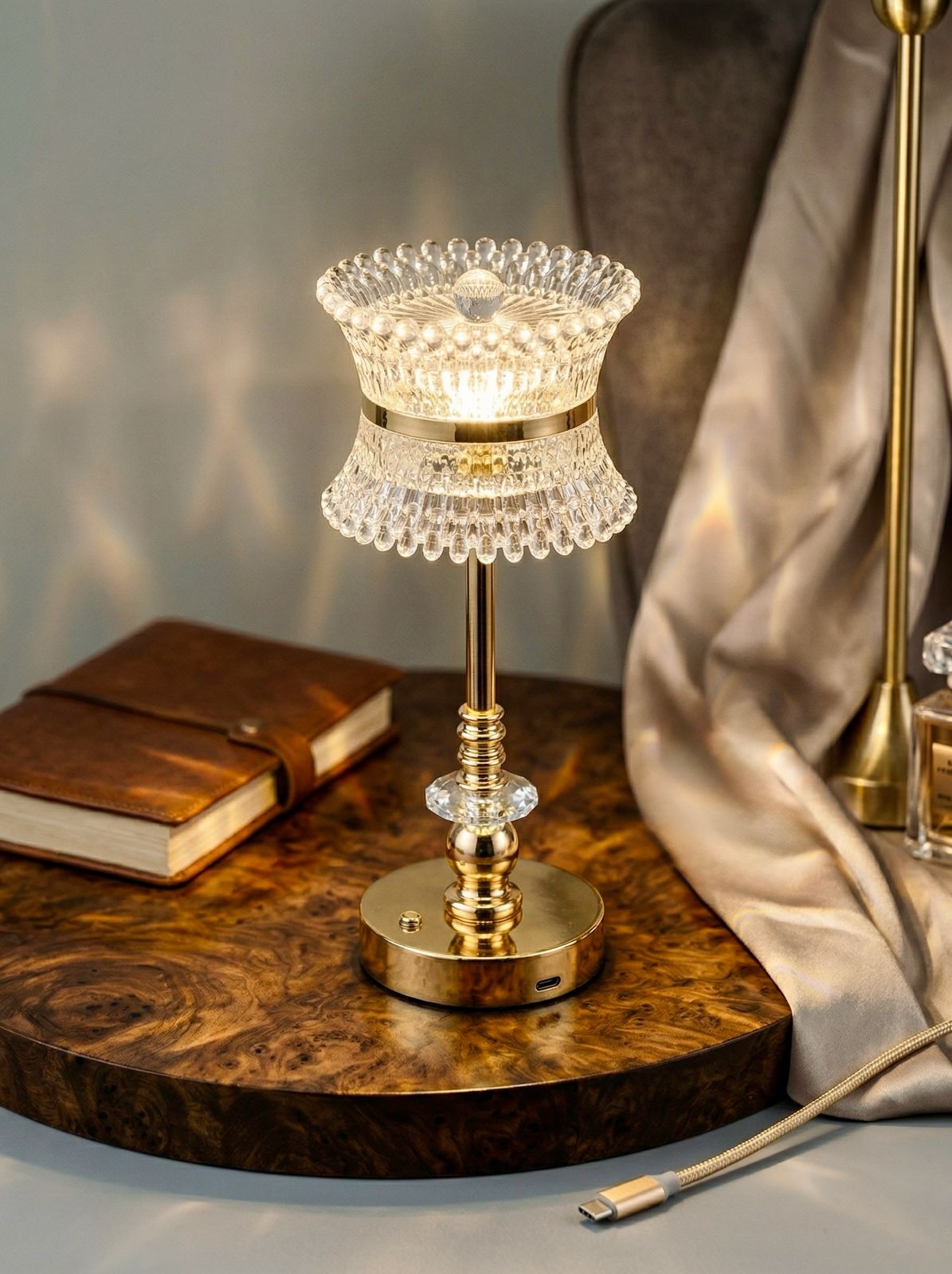 Gold Coatl Lamp glowing on a burl wood table beside a leather journal