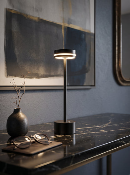 Black Alba Lamp on a dark marble console with a vase, glasses and abstract artwork behind