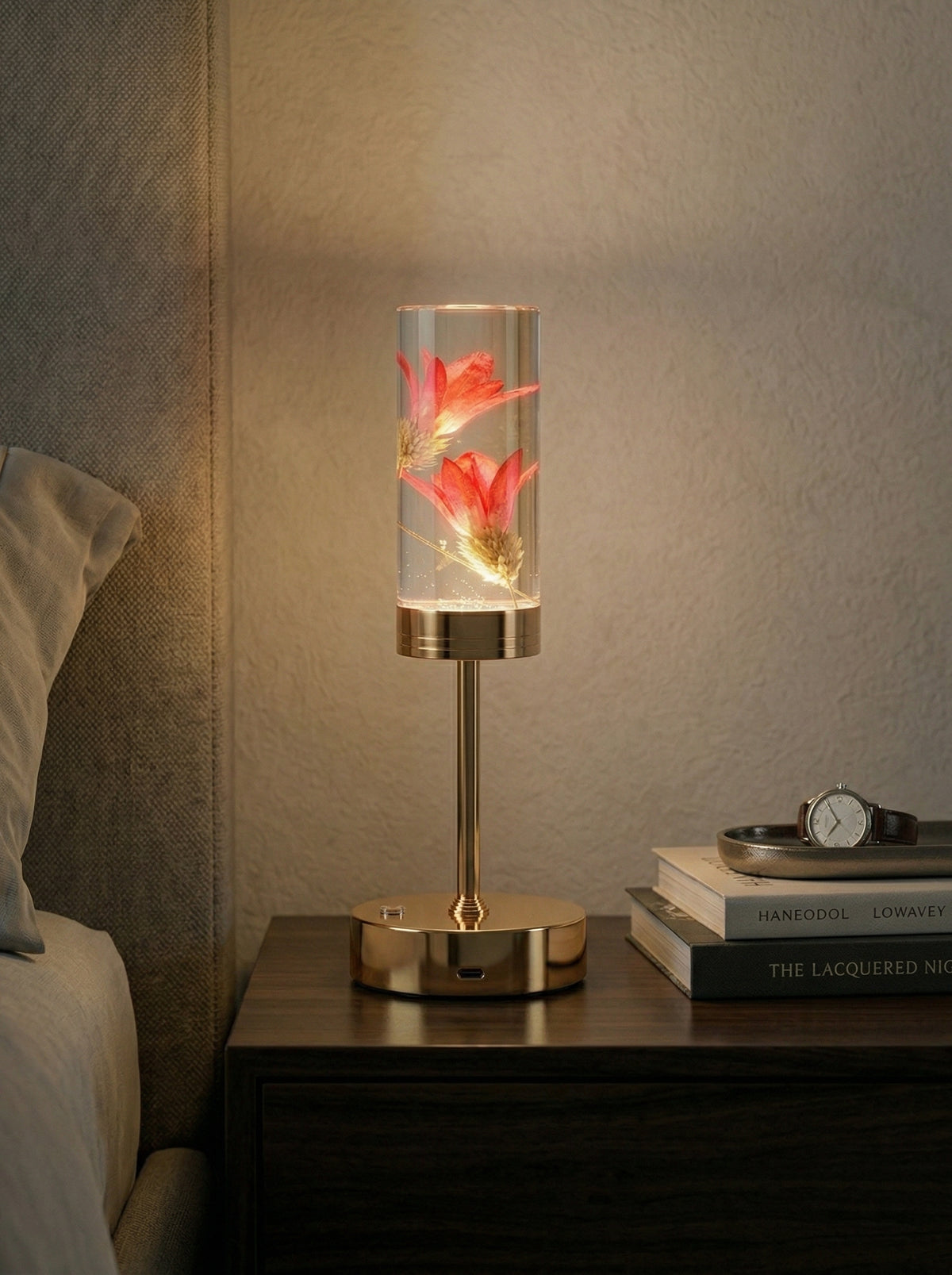 Gold and Red Phoenix Lamp glowing on a nightstand with books and a wristwatch