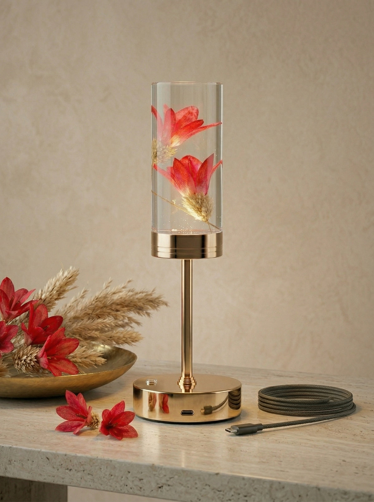 Gold and Red Phoenix Lamp on a stone surface beside a tray of red flowers and dried grass