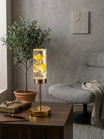 Gold and Yellow Phoenix Lamp on a wooden side table next to an olive tree and grey armchair