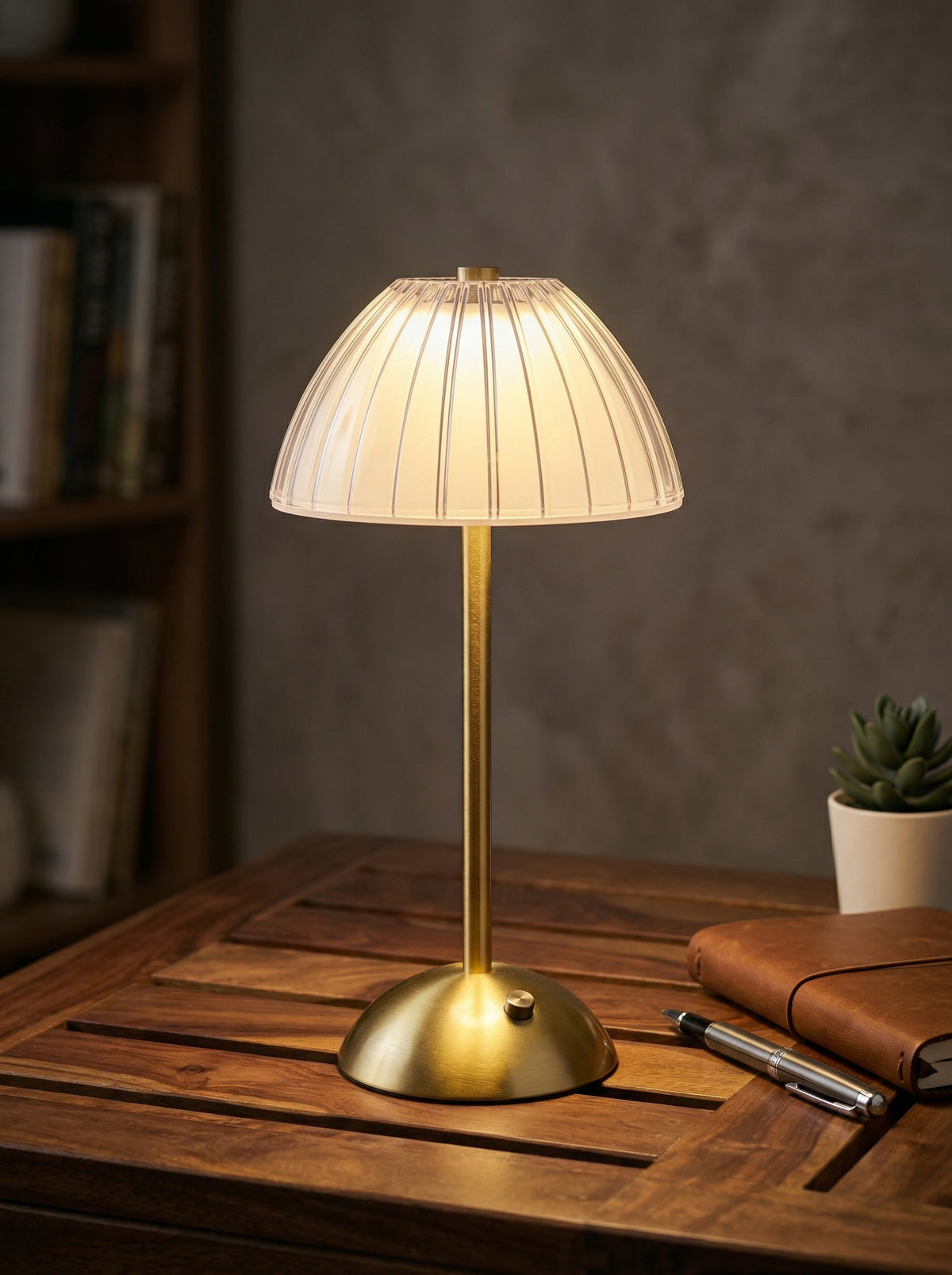 Gold Serin Lamp glowing on a wooden tray table beside a leather journal