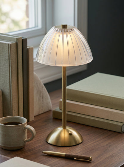 Gold Serin Lamp on a desk by a window with books and a mug of coffee